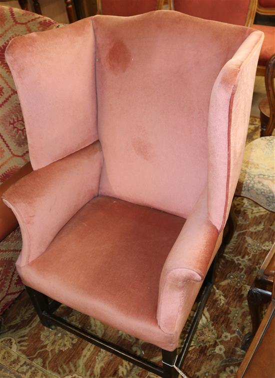 A George III mahogany framed pink dralon upholstered wing armchair